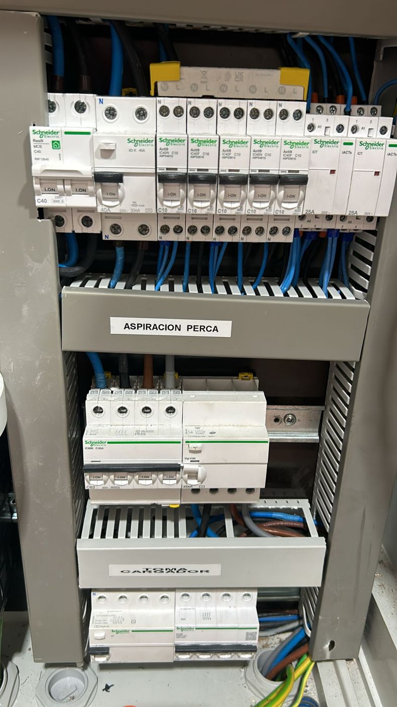 Cuadro eléctrico de taller industrial con protección de aspiración y toma para cargador, instalado por OLG
